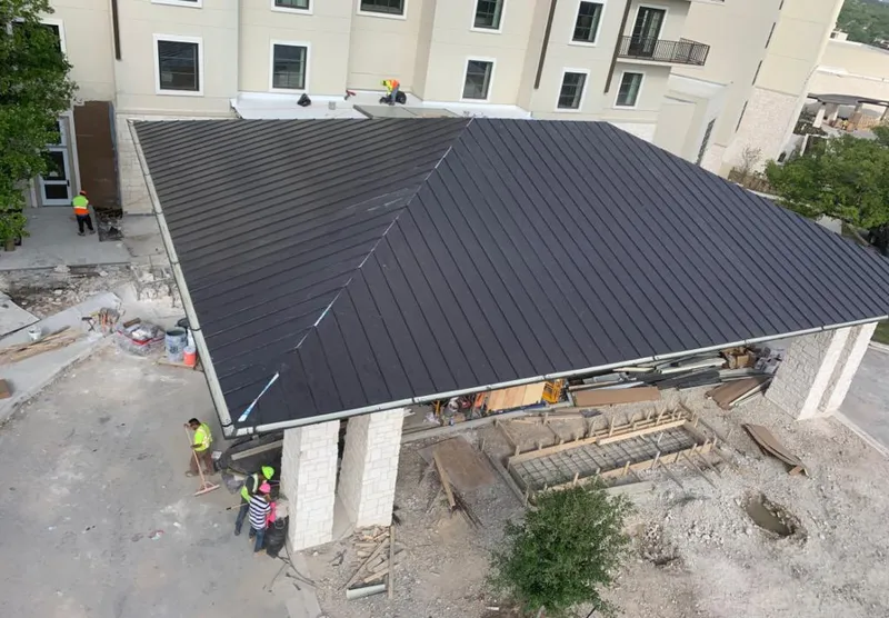 Metal roofing installation team working on a commercial building in Mentor